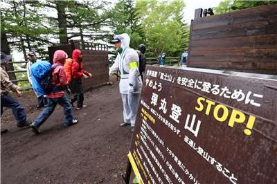 日本環境省將利用今年夏季於富士山頂新設的紅外線計數器量化人流，評估擁擠程度及管制成效。圖為登山客通過山梨縣五合目閘門，該閘門旨在防止人潮過多及夜間登山。資料照。（讀賣新聞/AFP）