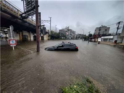 颱風杜鵑21日為日本關東地區帶來災情，神奈川縣鎌倉市一輛汽車被困在被洪水淹沒的街道上。