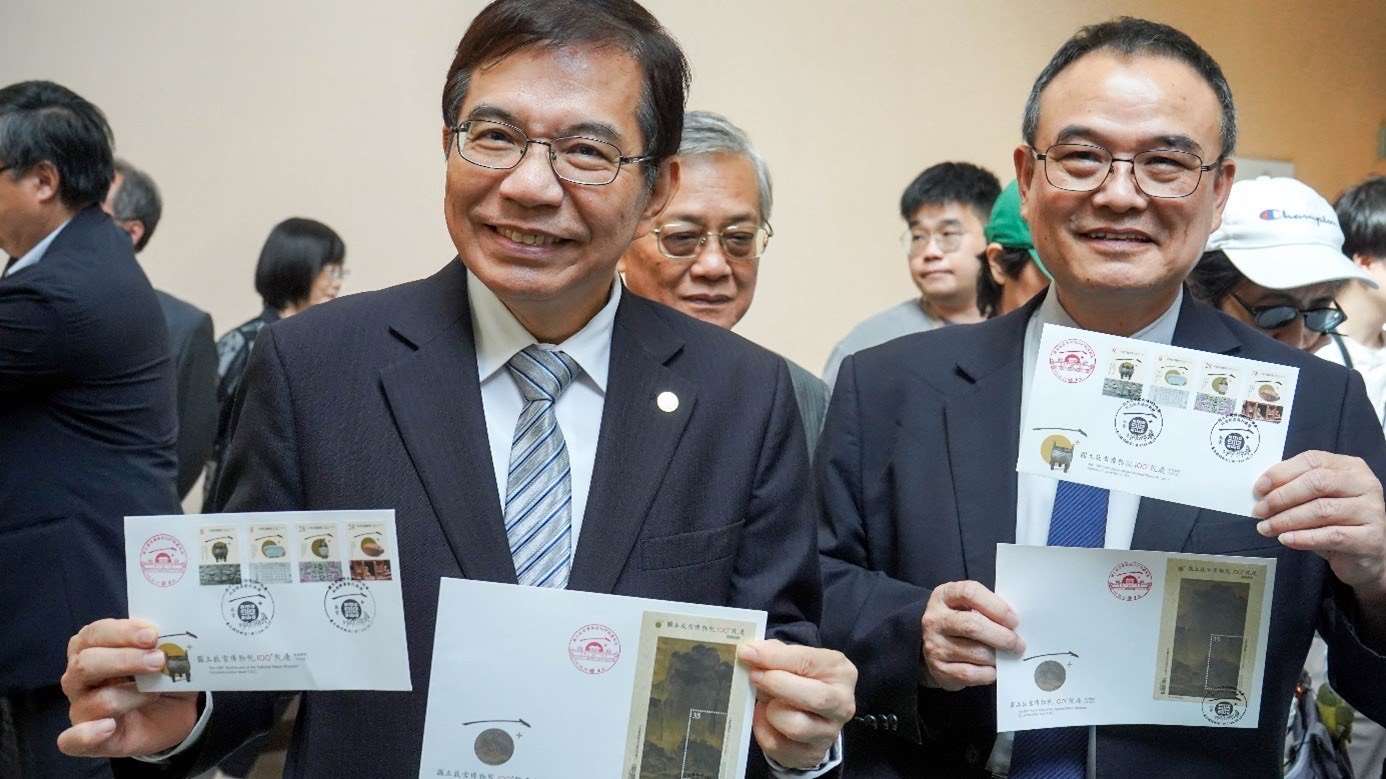 故宮博物院長蕭宗煌(右)、中華郵政公司董事長王國材(左)一同於台北臨時郵局體驗於首日封蓋銷「故宮一百週年慶」臨局戳服務。(中華郵政提供)