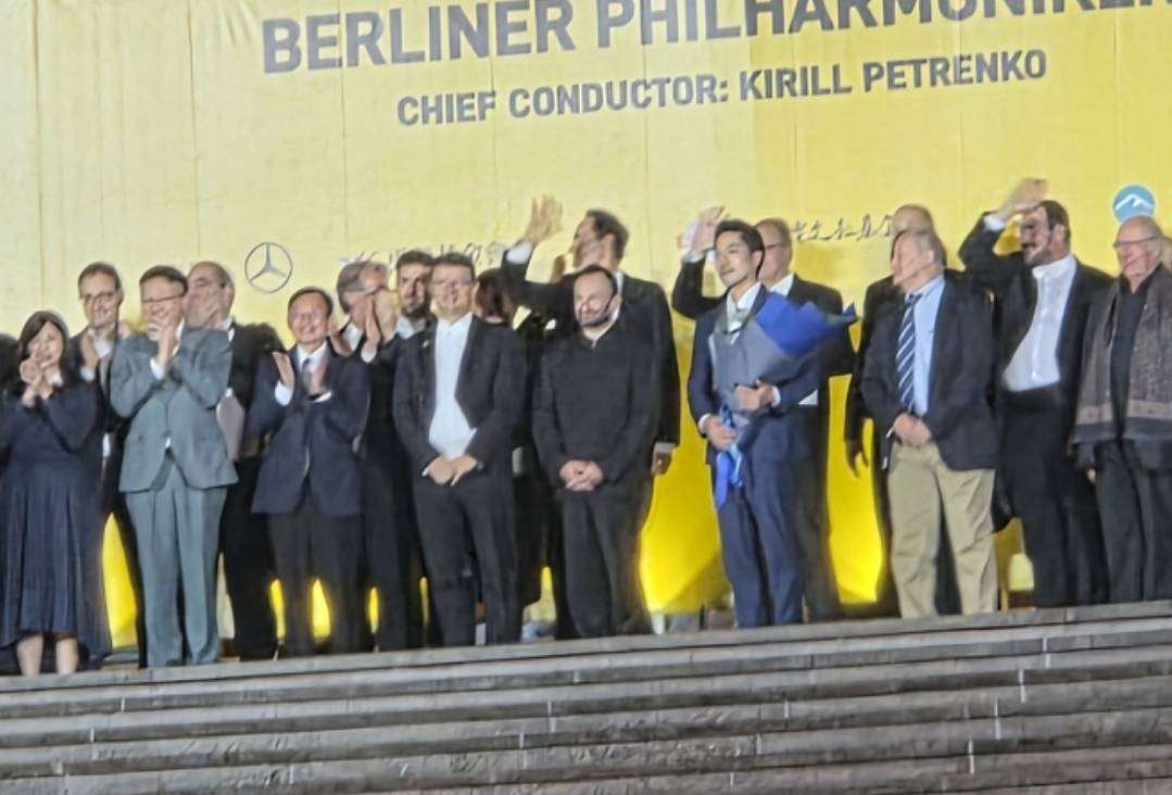 指揮佩特連科(前排右四)看到許多觀眾冒雨聆聽柏林愛樂演出，直呼不可思議，並允諾很快再回來。(江昭倫 攝)