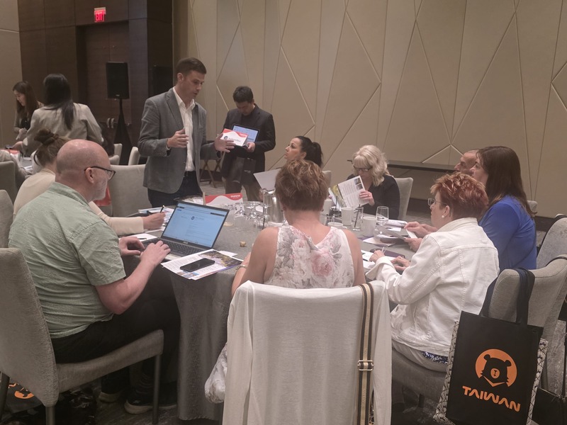 交通部觀光署11日偕同多家業者在加拿大推廣台灣觀
光，加拿大籍台灣女婿陳睿昱（Michael McCreesh，穿
灰西裝站立者）在台灣自創運動旅遊品牌，隨團到加
拿大向當地旅遊業者介紹台灣之美。