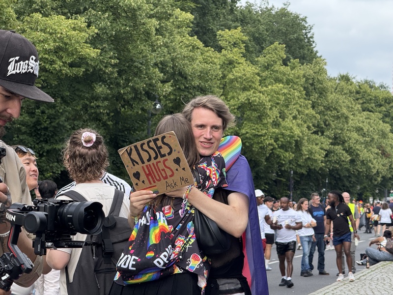 柏林驕傲遊行吸引各地民眾參與，不少年輕人高舉免費擁抱或親吻標語，主動向路過民眾送上溫暖擁抱，傳遞支持與包容的訊息。