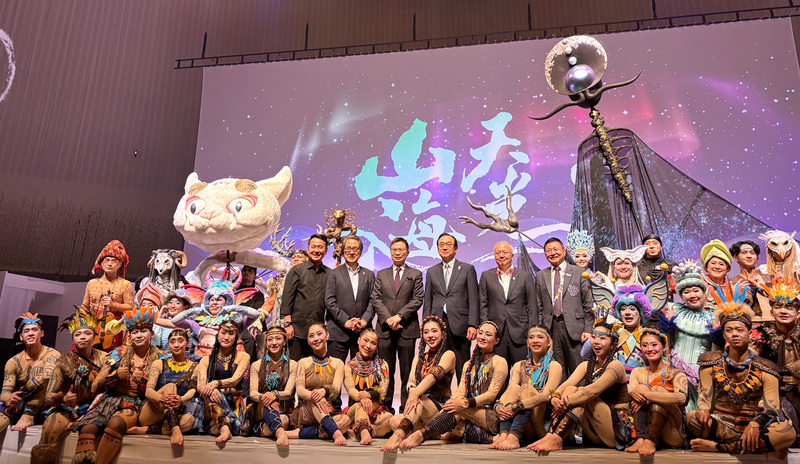 大阪世博TECH WORLD館8日於EXPO HALL舉辦「展館日」，邀請國際知名表演團隊「舞鈴劇場」演出「山海天光」，玉山數位科技株式會社榮譽會長黃志芳（站立左3）、導演劉樂群（站立左1）、大阪世界博覽會事務總長石毛博行（站立左2）、大阪府副知事山口信彥（站立右2）、TECH WORLD館長邱揮立（站立右1），於演出後合影。