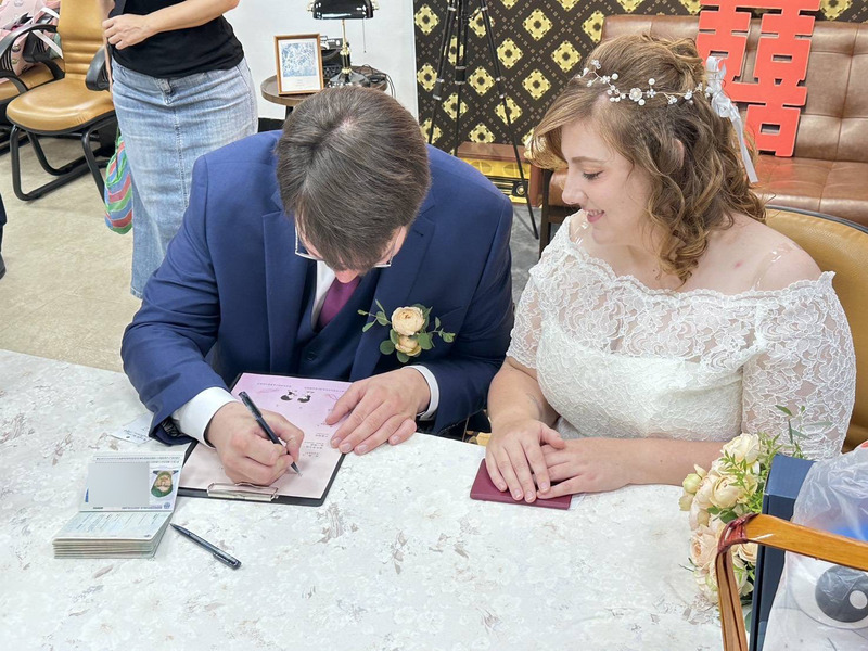 一對德國新人14日在台南市中西區戶政事務所填寫結婚登記資料，新郎Martin（左）一筆一畫寫下觀光署協助翻譯而取的中文名字。
（觀光署法蘭克福辦事處提供）
