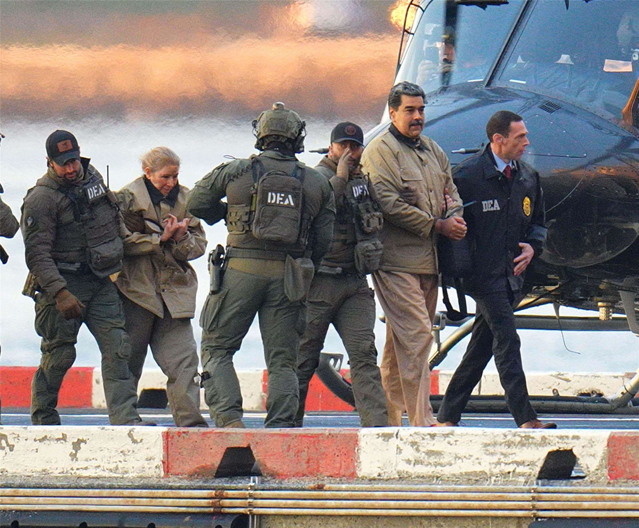 委內瑞拉總統馬杜洛(右二)和他的妻子佛洛雷斯(左二)在曼哈頓直升機停機坪降落後被戴上手銬，在全副武裝的聯邦幹員護送下，登上裝甲車前往位於曼哈頓的聯邦法院。(AP/達志影像)