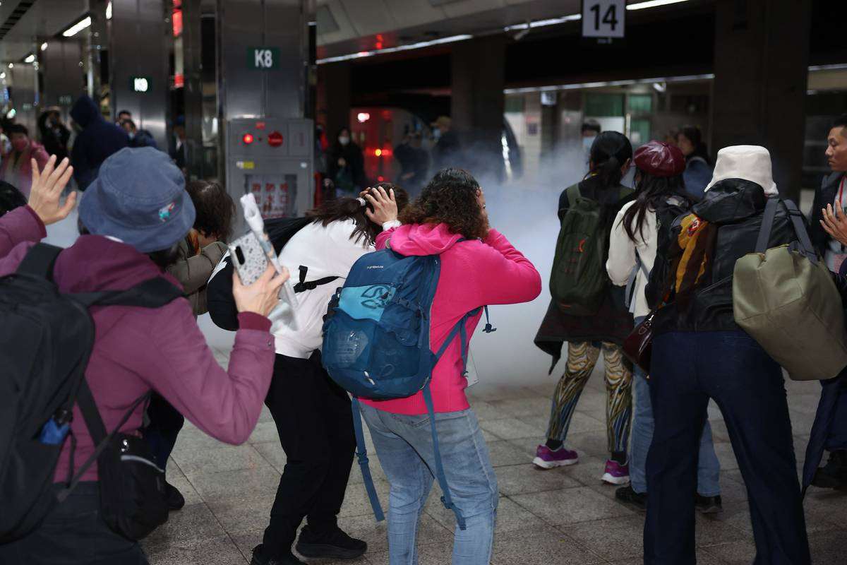 台北市政府與交通部為確保台北車站特定區面對突發危安事件的緊急應變能力，22日下午進行「無差別攻擊事件」聯合危安實兵演練。依規劃，第一階段模擬多名歹徒在台鐵月台丟擲煙霧彈後，引發旅客驚慌，台鐵立即通報110、119鐵路警察及回報聯防中心。(台北市政府提供)