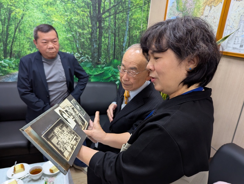 日治時期台中醫師石津坂一的後代石津宏（右2）12日在文史團隊協助下到訪台中市中區戶政事務所，申請父親石津坂一當年戶籍資料，並與戶所人員翻看老照片。
