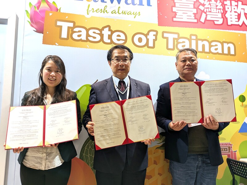 英國規模最大的國際食品飲料展（IFE）台南館30日開幕，台南水產及加工品生產供應商「鮮饌」總經理洪志民（右）與英國進口和供應鏈整合商Cherrain Global執行長Kris Tang（左）簽署合作備忘錄，台南市長黃偉哲（中）擔任見證人。
