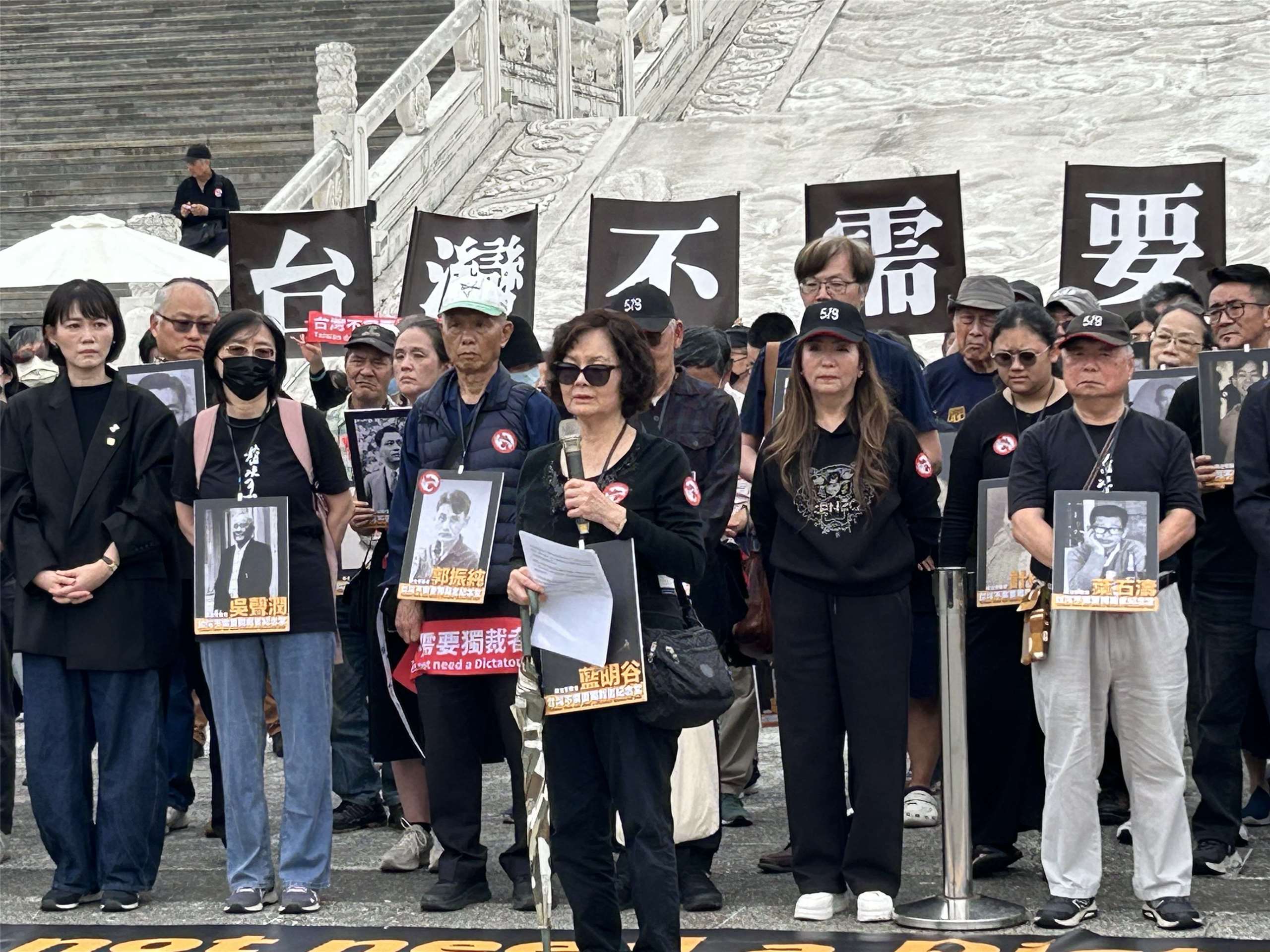 519行動組合及58個民間團體今天(5日)集結在中正紀念堂，發起「台灣不需要獨裁者紀念堂」行動。白色恐怖政治受難者藍明谷的女兒藍芸若(前)手捧著父親遺照，希望執政單位能盡速拆除蔣介石銅像。(趙婉淳 攝)