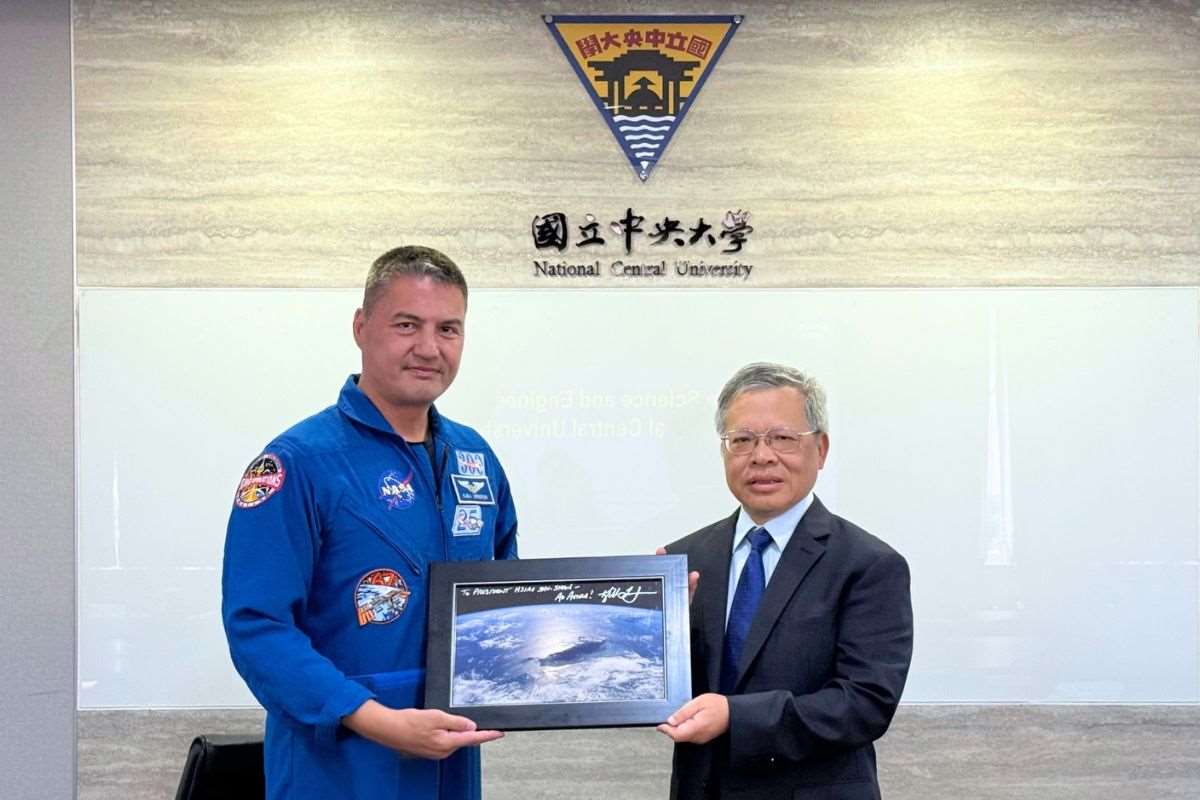 太空人林琪兒(左)致贈國際太空站下拍攝的台灣照片給中央大學校長蕭述三(右)。(中央大學提供)