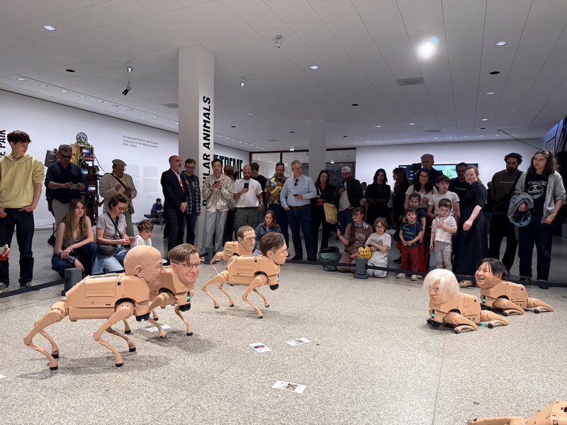 美國數位藝術家Beeple裝置作品「常規動物」於柏林新國家美術館展出，機器狗裝上獨裁者、改變世界審美的藝術家與科技巨頭臉孔，在展場中移動並透過人工智慧生成圖像，吸引觀眾圍觀。
