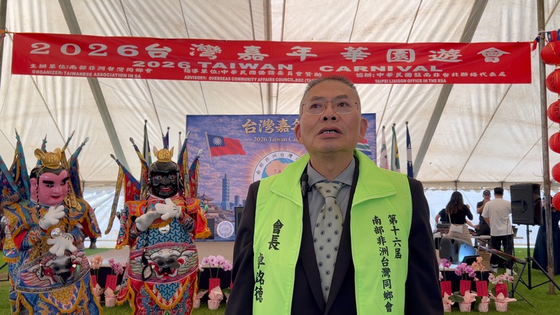 南非洲台灣同鄉會會長卓銘德於台灣嘉年華致詞，感謝僑界團體齊心協力，展現「台灣熊勇」團結力量；後方為三太子表演，呈現台灣文化特色。