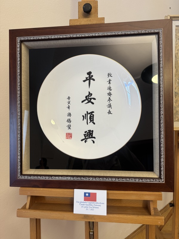 捷克參議院舉辦「禮物展」，當中展示2022年7月時任立法院院長游錫堃訪問捷克時，贈送參議院以毛筆字題寫「平安順興」的白色圓形瓷盤。