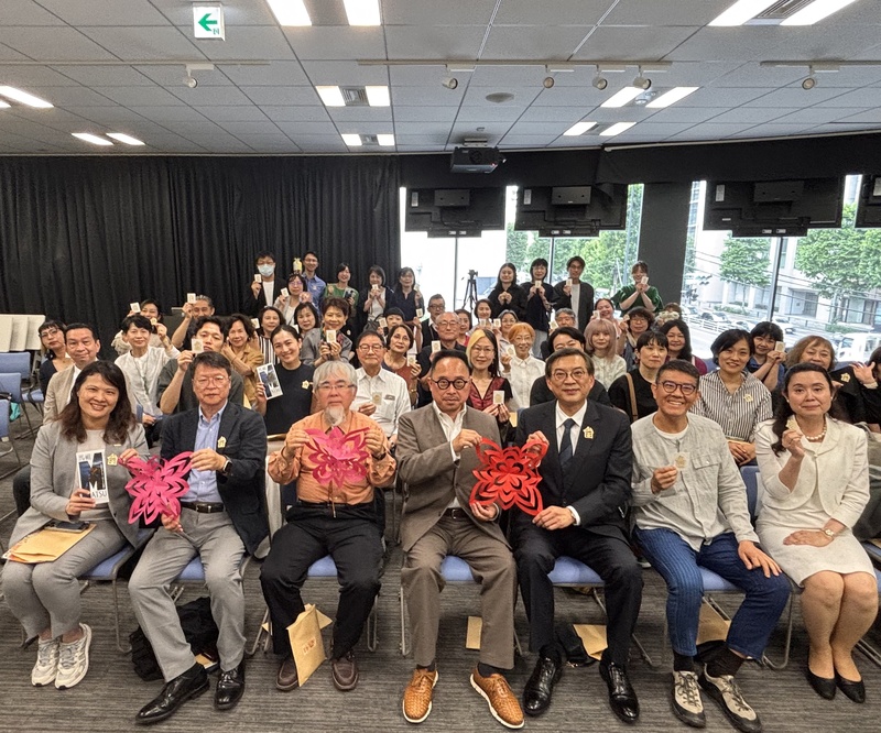 文化部駐日本代表處台灣文化中心主辦的「剪花・綻放－台灣剪紙藝術在馬祖」特展2日開幕，駐日副代表周學佑（右3）、台灣文化中心主任曾鈐龍（右4）舉著參展藝術家陳治旭（右2）於開幕式上現場完成的剪紙作品，與全場來賓合影。