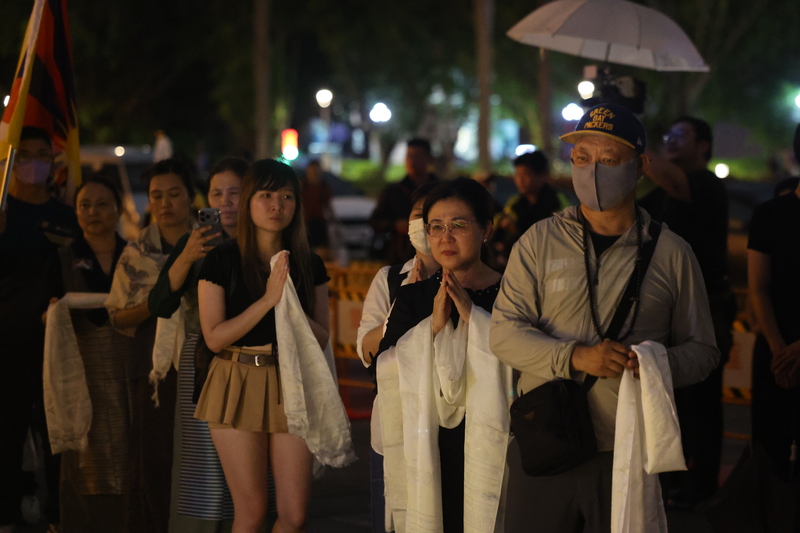 多個人權團體發起舉辦的「追悼洛嘎讓贊供身自焚 抗議中共民族團結促進法」活動15日晚間在台北自由廣場舉行，盼藉集會追悼自焚抗議的流亡藏人洛嘎讓贊。圖為與會民眾依序向洛嘎讓贊遺像獻上哈達。