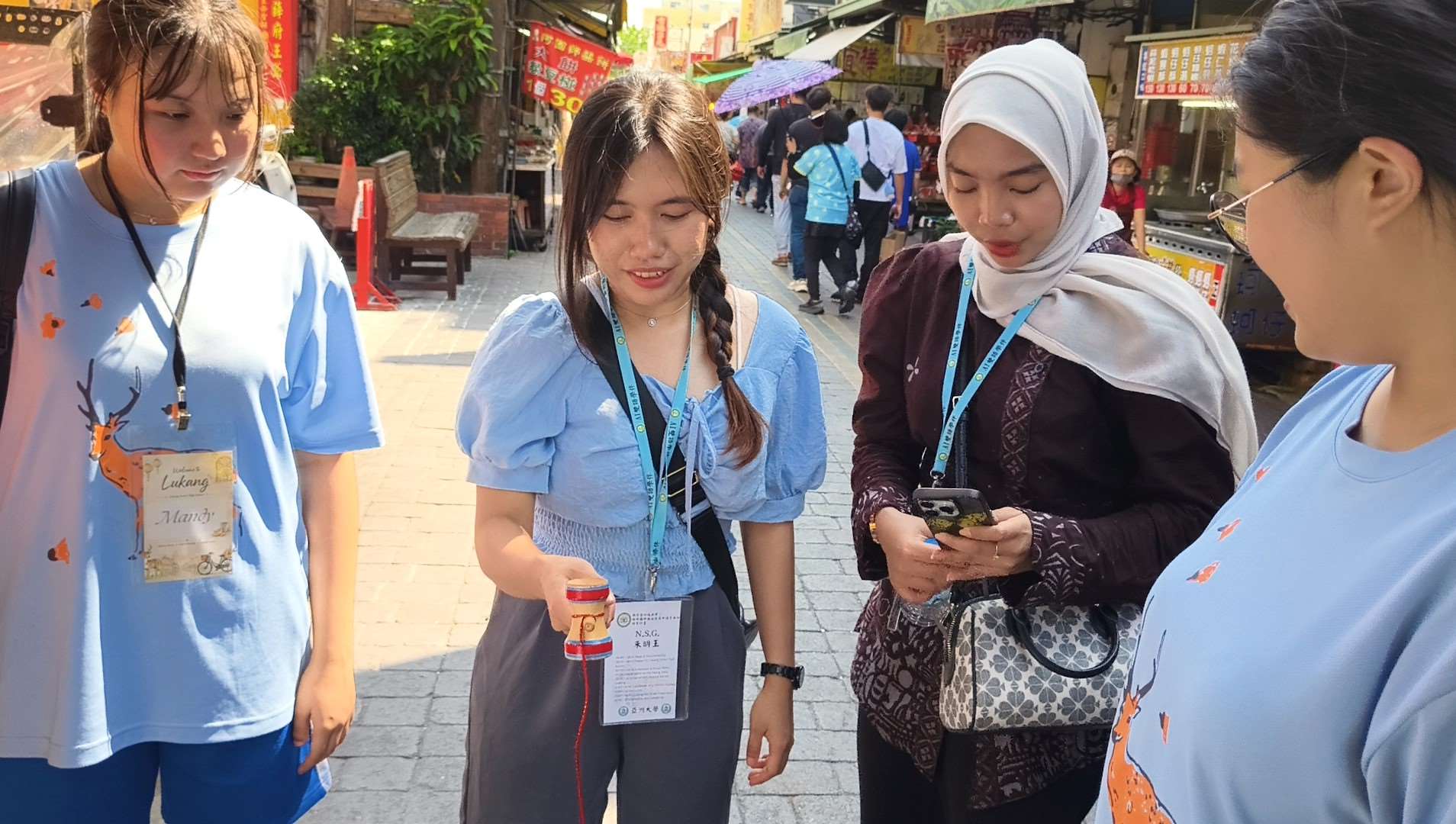 鹿港高中學生與國際學生漫遊鹿港老街，體驗台灣傳統童玩。(圖：亞洲大學提供)