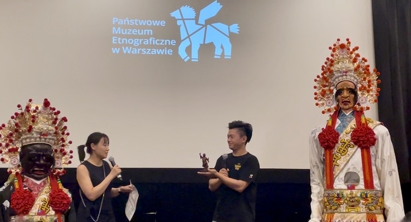 雷昇傳藝劇團執行總監王昇揚（右1）手持劇團守護神「田都元帥」尊像，向波蘭國家民俗博物館方介紹台灣民間信仰典故與陣頭文化。