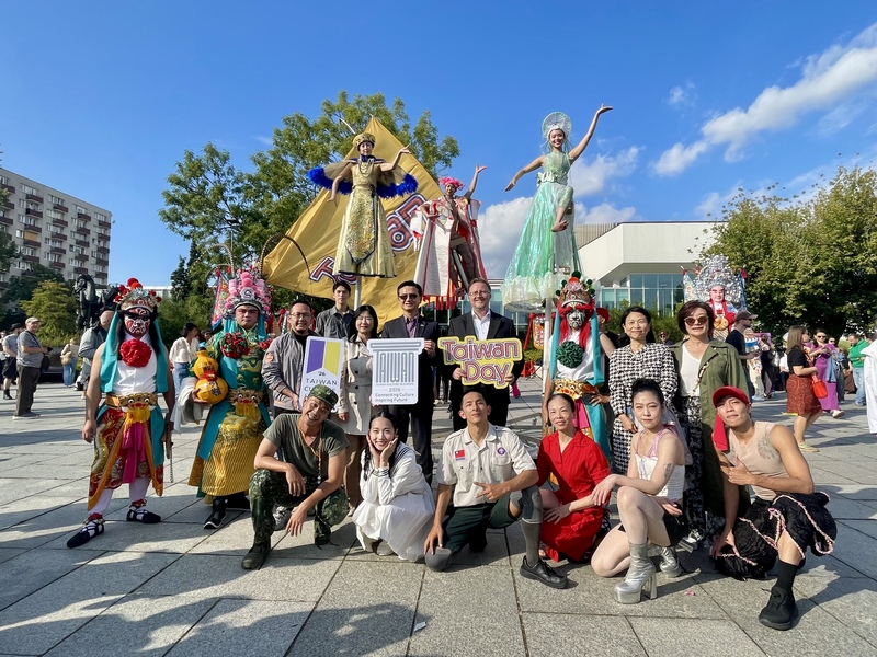 三團共演「默島進行曲」大成功，表演後何曉玫MeimageDance舞團舞者、雷昇劇團神將與駐波蘭代表劉永健（後排中間持「TAIWAN」牌者）、奧坡副市長烏耶茨（後排中間持「Taiwan Day」牌者）、文總秘書長李厚慶（後排中間持紫黃牌者）與編舞家何曉玫（後排右1戴墨鏡者）合影留念。