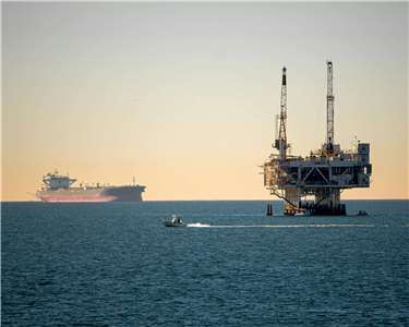 Ілюстративне фото: нафтова платформа та контейнеровоз у морі. (Фото: Thomas Parker/Pexels)