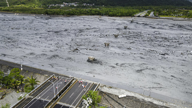 Фото: повінь і потоки бруду знесли міст над струмком Матайʼан після переливу загатного озера. (CNA)