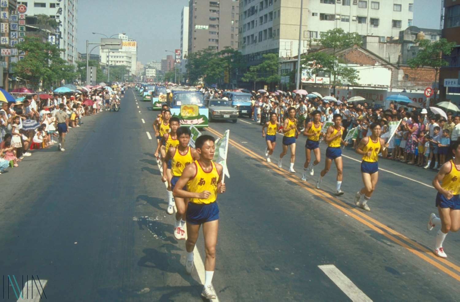 Учні-спортсмени старшої школи Кайнань очолюють колону з тваринами. (Фото: Національне управління архівами)