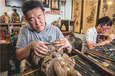 Nghệ nhân phục chế thần tượng Kim Minh Vĩ (trái), được biết đến với biệt danh “A Bảo sư”, năm 2021 được thành phố Tân Bắc ghi danh là người gìn giữ  kỹ thuật bảo tồn di sản văn hóa “phục chế tượng Thần”,  với hơn 30 năm làm nghề, ông đã phục chế hơn 10.000 bức tượng thờ (Ảnh: CNA - nguồn: Đền Hà Hải Thành Hoàng)