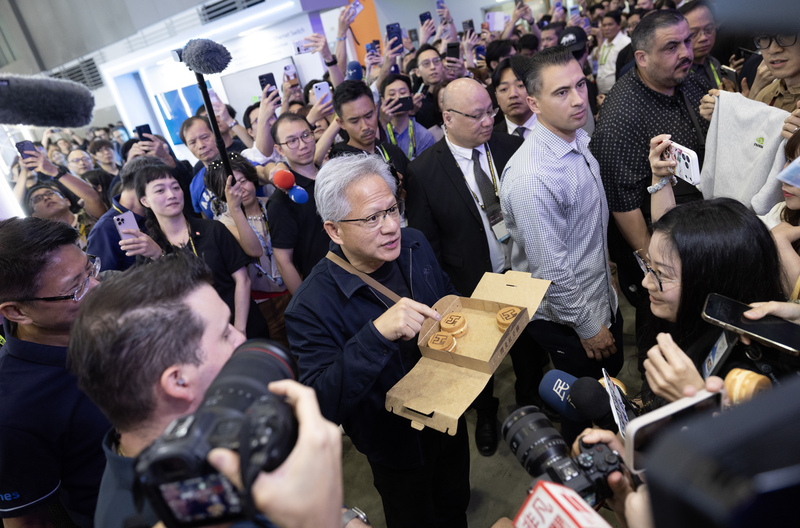 CEO Nvidia Jensen Huang tham quan khu vực triển lãm của Foxconn, phát bánh đậu đỏ cho mọi người cùng thưởng thức (ảnh: CNA)