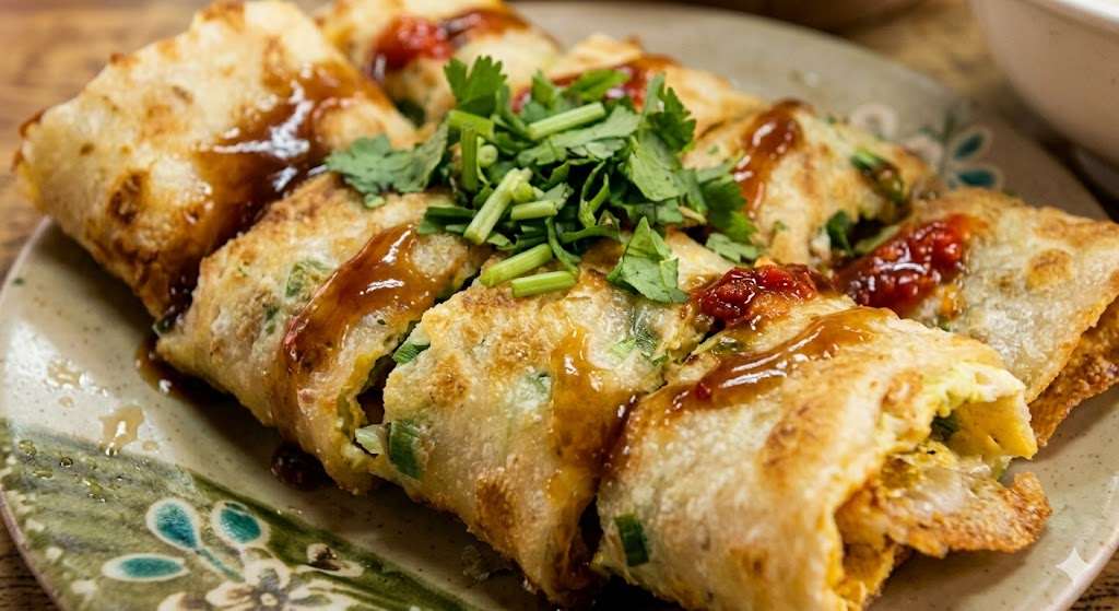 Bánh trứng được làm từ bột mì cuộn thêm một lớp trứng chiên và được thêm các loại nhân tùy sở thích của thực khách là món ăn sáng mang đậm dấu ấn riêng của Đài Loan (Ảnh: AI)