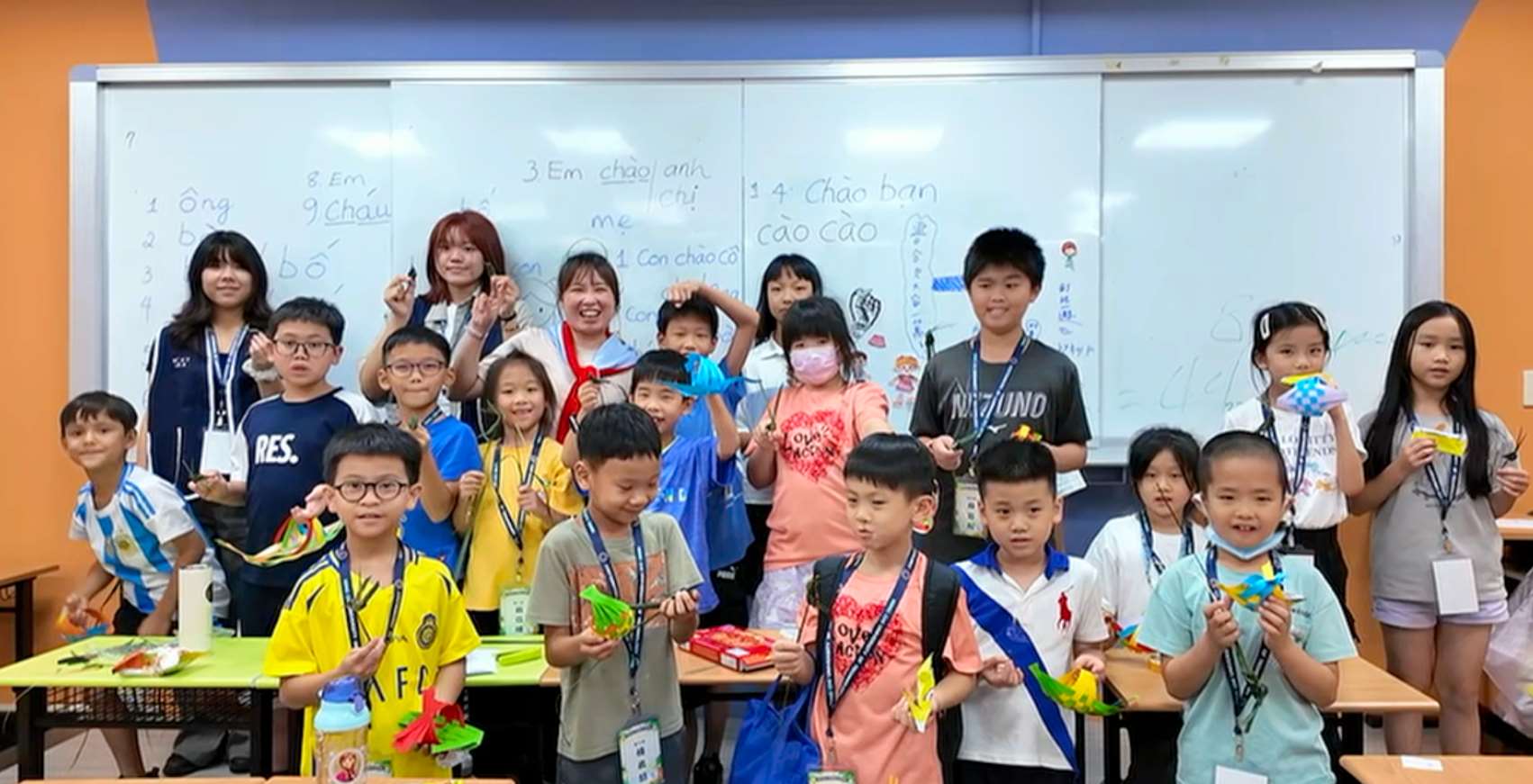 Các em học sinh hào hứng với tác phẩm thuyền đan bằng giấy và cào cào lá dừa của mình